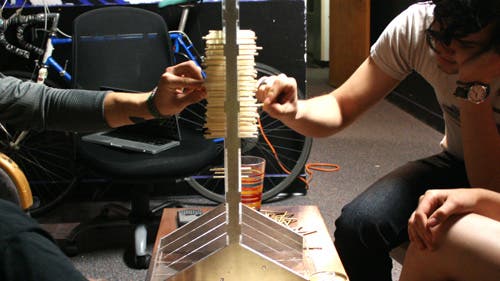 Hands on both sides of the a plexiglass rack to remove sticks.