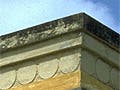 A photo of the Palace of Minos in Crete, specifically a balcony with three columns in front of a painted wall.