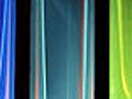 small, semi-transparent vials ranging in color from red to orange, yellow, green, and blue.