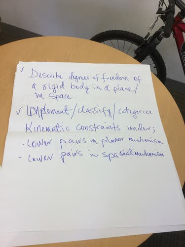 Sample learning outcomes written in magic marker on an oversized sheet of paper.