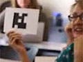 Students holding up cards with images on them that can be scanned as voting devices.