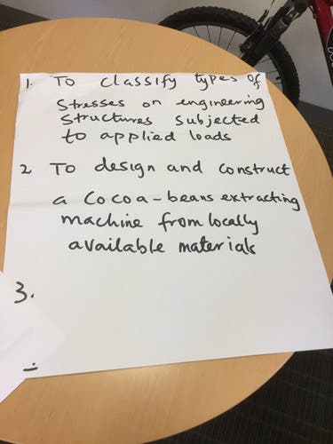 Sample learning outcomes written in magic marker on an oversized sheet of paper.