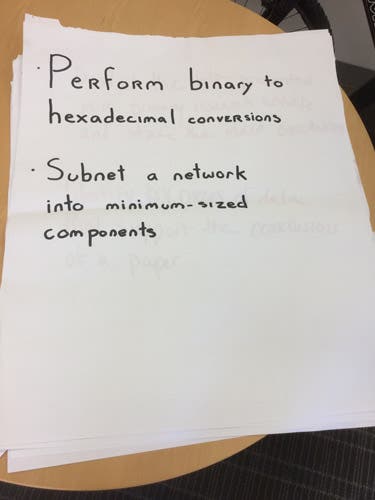 Sample learning outcomes written in magic marker on an oversized sheet of paper.
