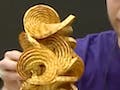 Prof. Demaine holds up a swirling origami figure.
