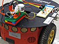 Three images, one of the completed robot with light-tracking head, and close-ups of the breadboard and Lego head.