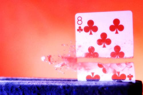 8 of clubs just after bullet splits the card in two.