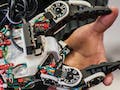 Image of someone standing behind a robotic arm with exposed wires.