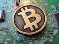 Bitcoin keychain over circuit board.