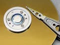 A photograph of a platter and actuator arm from a computer hard drive.