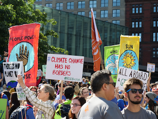 Crowd holding signs at a climate strike.