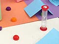 Students sitting around a homemade board game with several game pieces on it.
