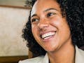 Smiling business woman shaking hands with another person. 