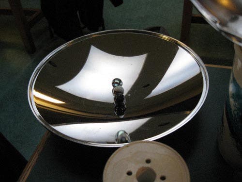 Photo of marbles resting on the surface of a curved mirror.