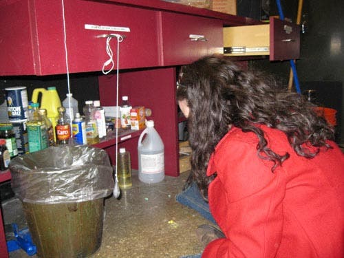 Photo of a student observing a simple pendulum consisting of a metal weight hanging from a drawer handle.