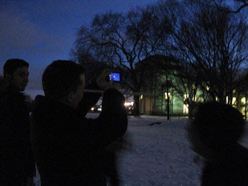 Photo of a student pointing his phone toward the object to identify it.