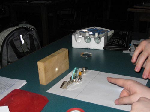 Photo of the image that light shining through a lens projected onto a block of wood.