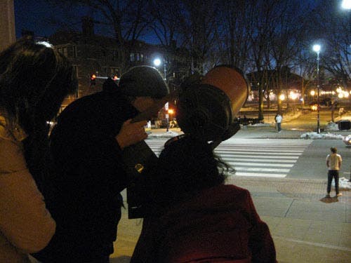 Photo of students observing the night sky with a Celestron reflector telescope.