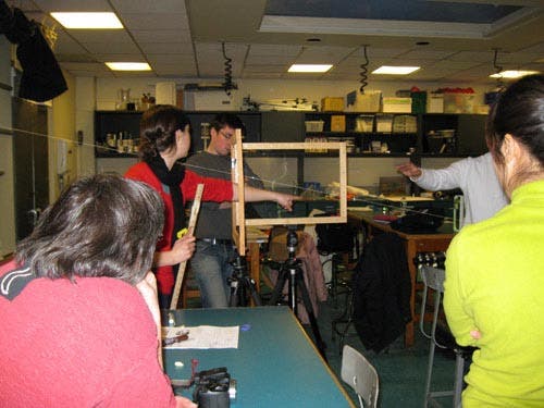 Photo of students viewing along the string to the lute. 