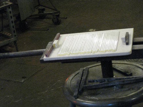 Photo of the white glass rods arranged in a neat row on a table.