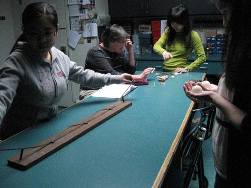 Photo of a student working with a ball on a ramp with multiple hills.