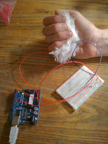 Photo of squeezing an early prototype, connected to the circuit board.