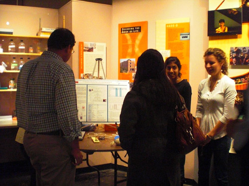 A photo of the team speaking with attendees at the poster session.