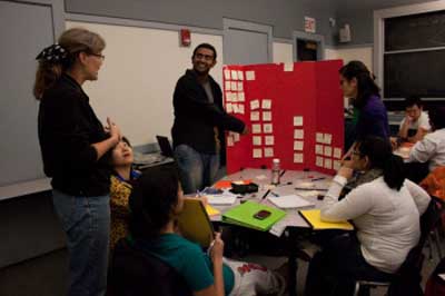 Photo of instructor Amy Smith with several students and a poster board.