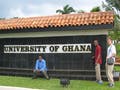 A photograph of three MIT students at the entrance of the University of Ghana.