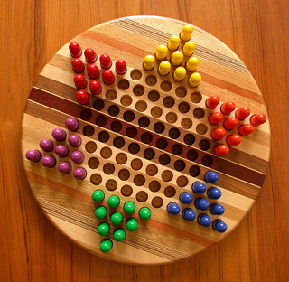 A star shaped board with different colored pegs in each corner.