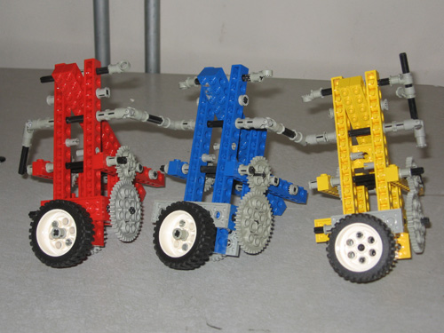 A Lego robot with three tall triangular-framed units.