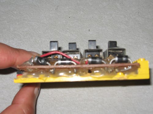 Four switches mounted on a section of perfboard, with resistors and sensor inputs.