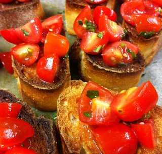 Tomatoes sit on top of toasted slices of bread.