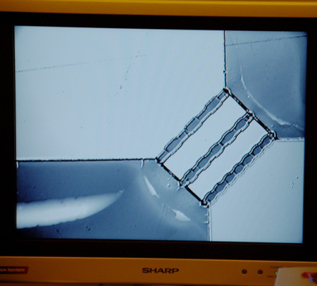 Close-up of wafer pattern on video microscope screen.