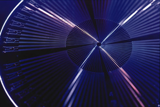 A photo of fast-moving colored lights which appear to be spinning in a circle above a machine.