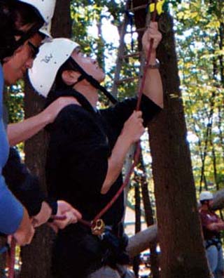 Photo of a student belaying on a ropes course.