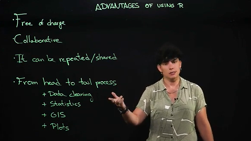 A woman standing next to text at a display board.