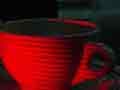 Light from a laser-illuminated coffee cup interferes with a holographic image of itself in the laboratory, producing a series of coarse interference fringes.