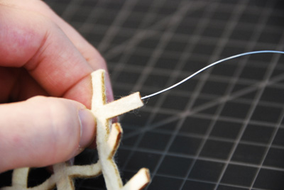 Photo showing a piece of wire going into a thin piece of felt.