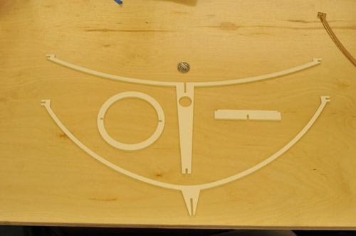 Photo of four pieces of plastic that will be assembled into the lamp stand.