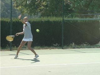 An MIT tennis team member hits a forehand.