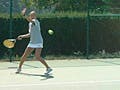 An MIT tennis team member hits a forehand.