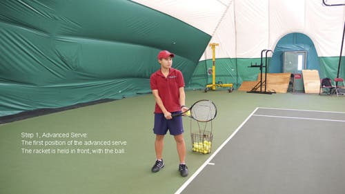 The racket is held in front, pointing towards the net, with the ball in the left hand near the racket neck.