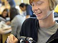 A photograph of a girl holding parts of a programmable camera as part of the Girls Who Build Cameras workshop.