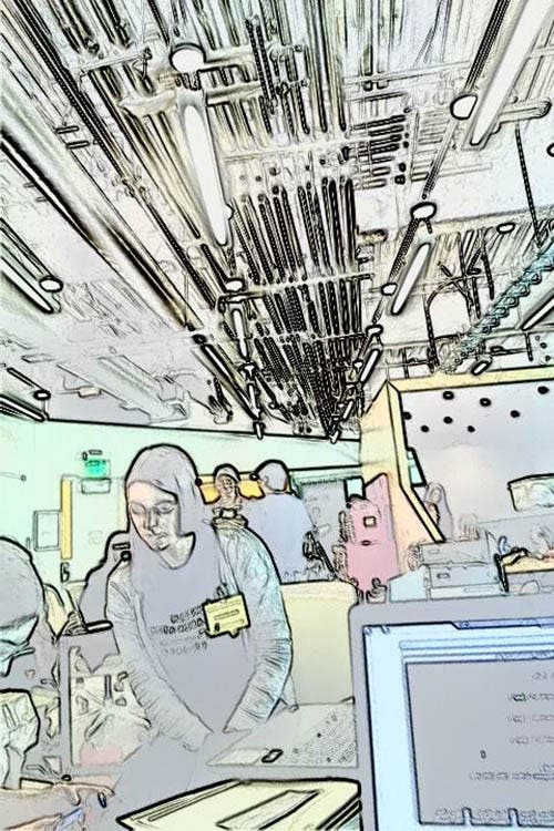 A blurry photo of a girl sitting at a desk.