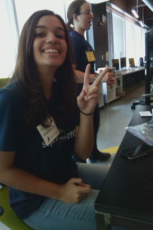 A photo of a girl giving a peace symbol with her hand.