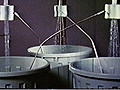 Top: A photograph of two streams of water running into buckets and producinng DC current. Bottom: A photograph of a three-stream water running system that produces AC current.
