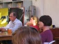 people sitting around tables, listening to a lecturer (not pictured)
