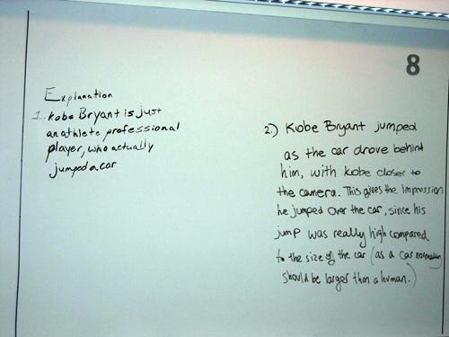 Notes on a whiteboard that explain the video of Kobe Bryant jumping over a car. It reads "Kobe Bryant jumped as the car drove behind him with Kobe closer to the camera. It gives the impressions he jumped over the car..." 