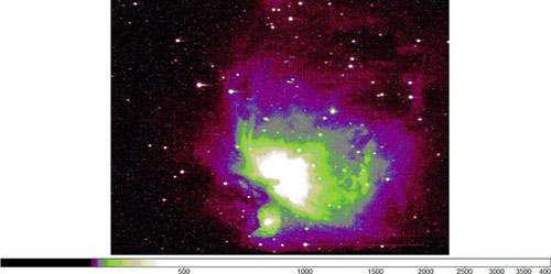 An image of Orion, a black background with green and purple in the middle. 