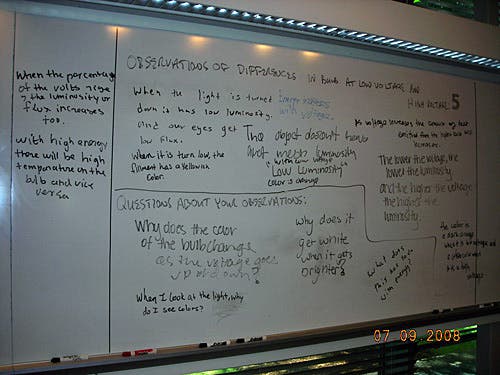 Handwritten notes on a whiteboard about differences in bulbs at low voltage and high voltage.